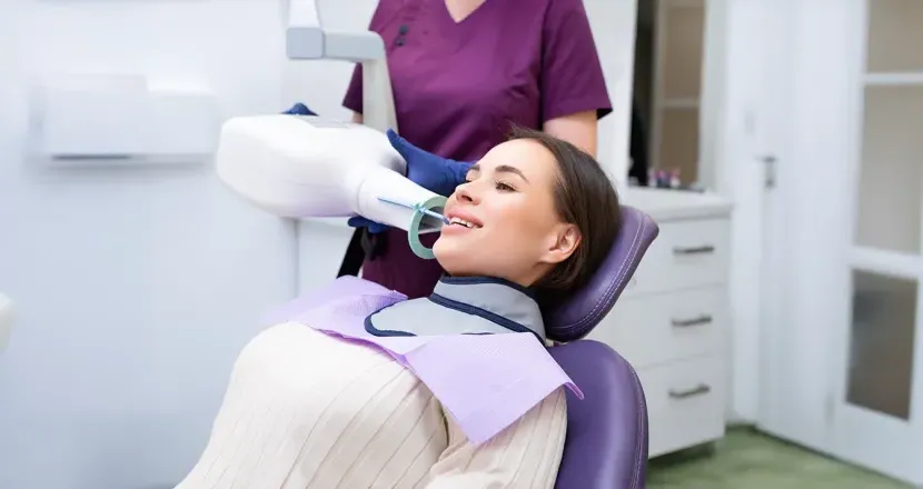 A dental professional using advanced radiology equipment to capture a dental X-ray, representing hands-on training in Herzing University’s dental radiology certificate program.